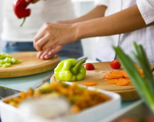 a person cutting up vegetables on a cutting board at Borbon Home luxury rooms & SPA in Palermo