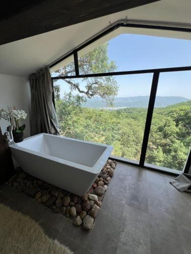 una vasca da bagno in una stanza con una grande finestra di Alex House a Aïn Draham