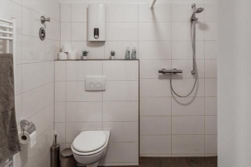 a white bathroom with a toilet and a shower at Apartment - 3 Einzelbetten - Stellplatz - Netflix in Goch