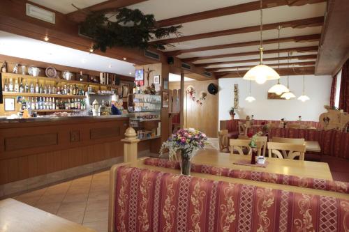 una sala da pranzo con tavolo e bar di Hotel Alpino Plan a Selva di Val Gardena