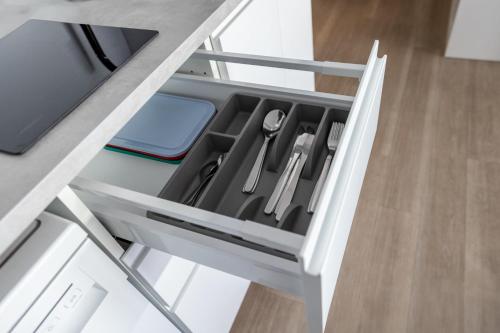 an open kitchen drawer with utensils in it at Kleines zentrales Apartment in Goch - Netflix in Goch