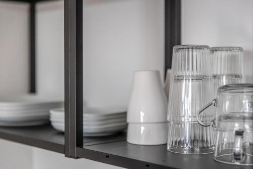 a shelf with glasses and plates and a mirror at Kleines zentrales Apartment in Goch - Netflix in Goch