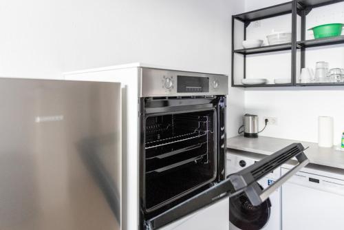 a stainless steel refrigerator with an open oven in a kitchen at Kleines zentrales Apartment in Goch - Netflix in Goch