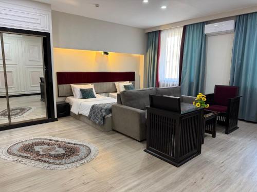 a bedroom with a couch and a bed in a room at Nemi Museum Art Hotel in Baku