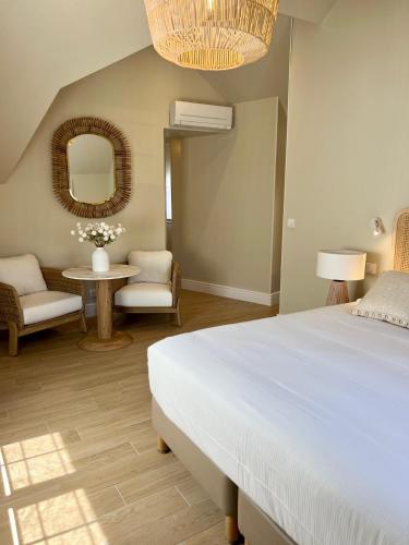 a bedroom with a bed and a table and a mirror at Hôtel Le Fer à Cheval in Trouville-sur-Mer