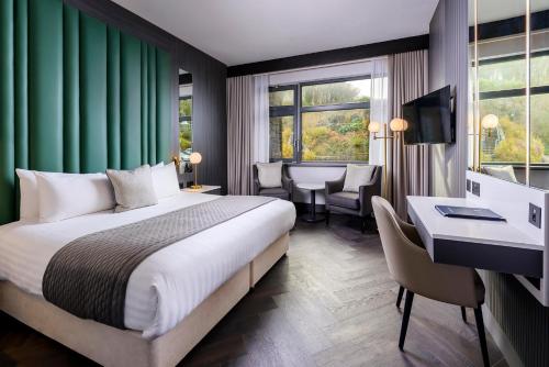 a hotel room with a bed and a desk and a room at Kinsale Hotel & Spa in Kinsale