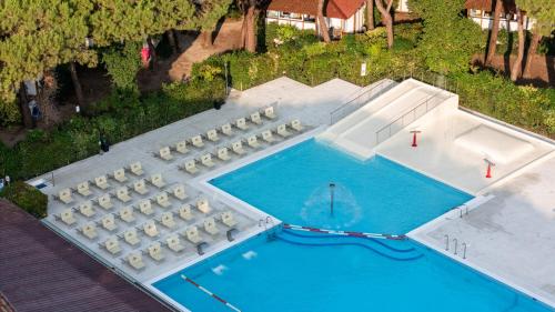 an overhead view of a swimming pool with white tables and chairs at Club del Sole Jesolo Family Resort in Lido di Jesolo