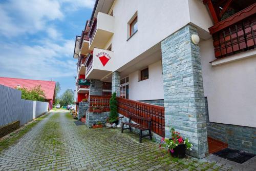 a building with a bench in front of it at Rodinný penzión Rogalo in Mengusovce