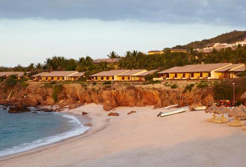 a beach with a group of houses on a cliff at Four Seasons Resort Punta Mita in Punta Mita