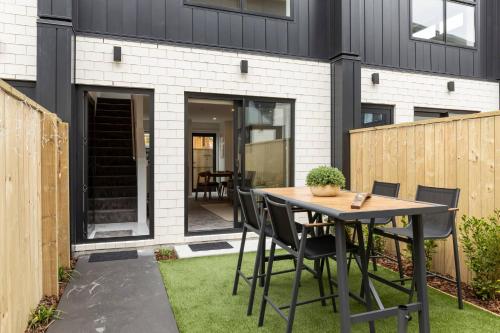 a patio with a table and chairs in front of a house at Luxury Apartment Christchurch Central in Christchurch