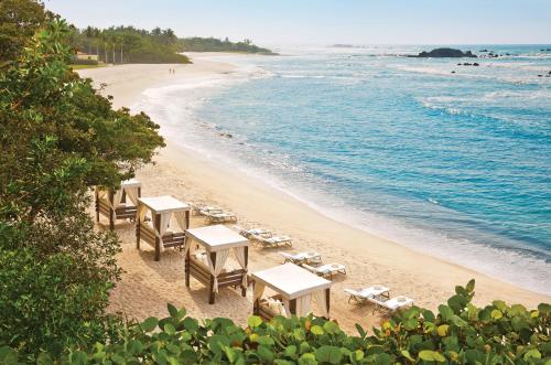 a group of tables and chairs on a beach at Four Seasons Resort Punta Mita in Punta Mita