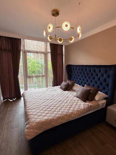 une chambre avec un grand lit et un lustre dans l'établissement Апартаменти SeaGems, à Karolino-Buhaz
