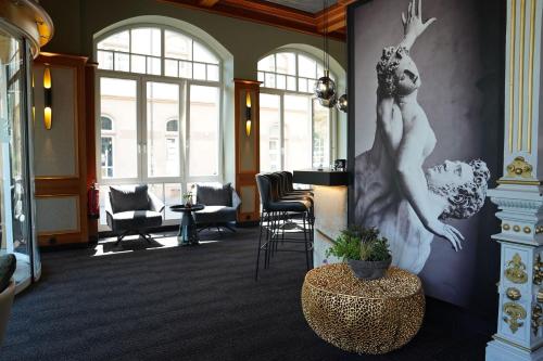 a lobby with a statue of a woman on the wall at Hotel Porta Nigra VICTUS in Trier