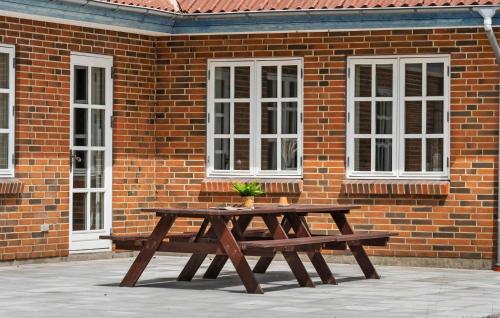 a wooden picnic table in front of a brick building at 3 Bedroom Beautiful Home In Videbæk in Videbæk