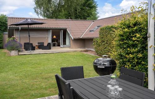 Una mesa y sillas con parrilla en un patio trasero. en 4 Bedroom Nice Home In Hejls, en Hejls