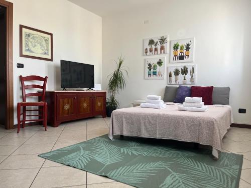 a bedroom with a bed and a tv and a chair at Dimore Al Borgo in Montagnana