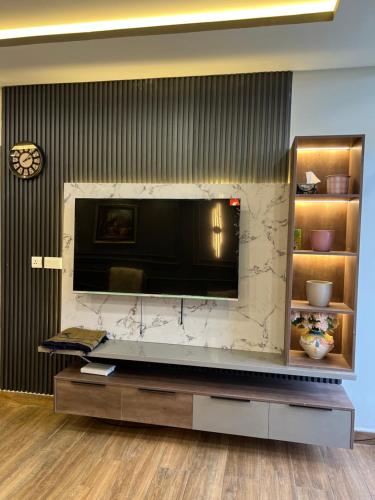 a living room with a large television on a wall at Blue sky Apartment in Nathia Gali