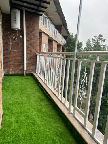 a balcony with green grass at Blue sky Apartment in Nathia Gali