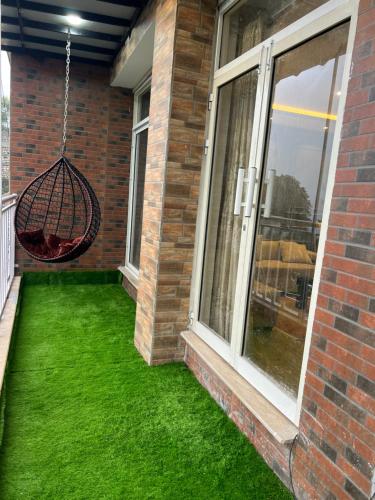 a yard with green grass next to a window at Blue sky Apartment in Nathia Gali