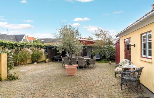 a patio with a table and chairs and a tree at Cozy Apartment In Gilleleje With Wifi in Gilleleje