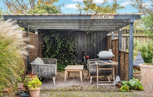 a pergola with chairs and a table in a garden at Cozy Apartment In Gilleleje With Wifi in Gilleleje