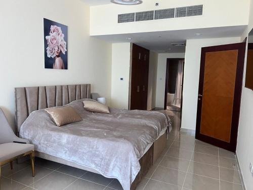 une chambre avec un lit et une chaise dedans dans l'établissement Beachfront Paradise - Ajman Corniche Residence, à Ajman