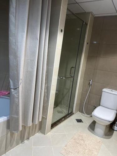 a bathroom with a shower curtain and a toilet at Beachfront Paradise - Ajman Corniche Residence in Ajman 