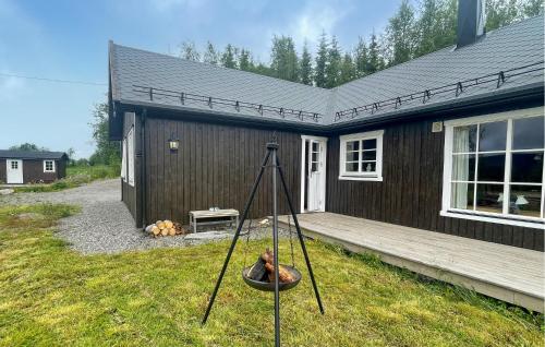 a house with a fire pit in front of it at Awesome Home In Trysil With Sauna in Trysil