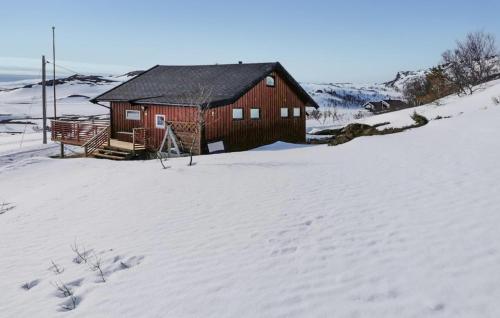 Pet Friendly Home In Snefjord With Sauna في Snøfjord: كابينة حمراء في الثلج مغطاة بالثلوج