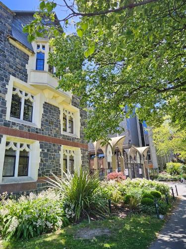 a large brick building with a garden in front of it at Luxury Apartment Christchurch Central in Christchurch