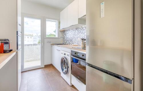 eine Küche mit einem Kühlschrank und einem Geschirrspüler in der Unterkunft Appartement Proche Plage in Royan