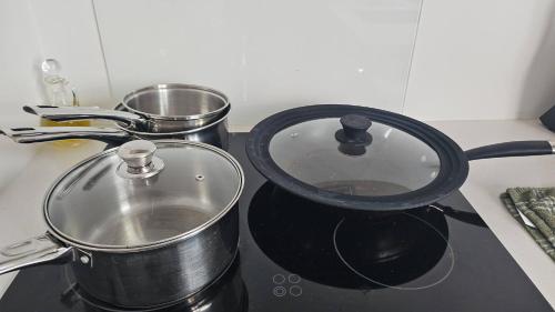 a pot sitting on a stove with two pans at Luxury Apartment Christchurch Central in Christchurch