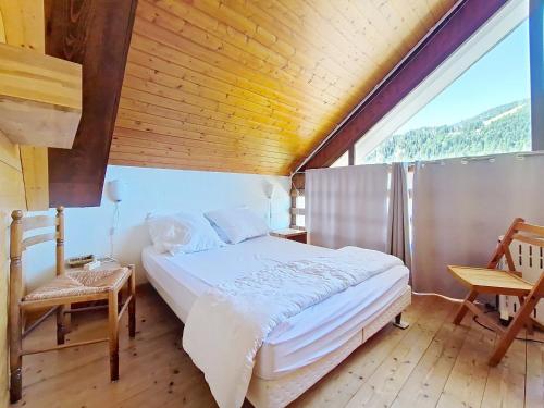 une chambre avec un grand lit avec un plafond en bois dans l'établissement Castel des Neiges CSA4 CENTRE & VIEW 6 Pers, à Châtel
