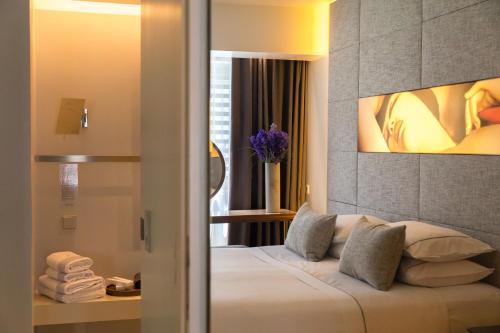 a bedroom with a bed with a painting on the wall at Brasil Suites Boutique Hotel in Athens
