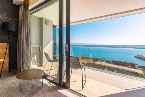 a room with a balcony with a view of the ocean at Hotel Villa Margaret in Malinska