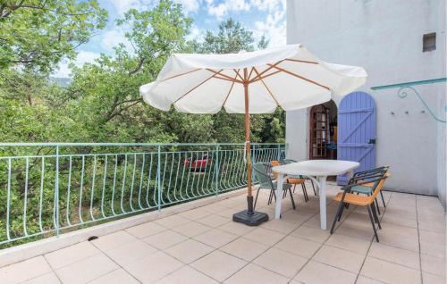 a patio with a table and an umbrella on a balcony at 3 Bedroom Awesome Home In Seillans in Seillans