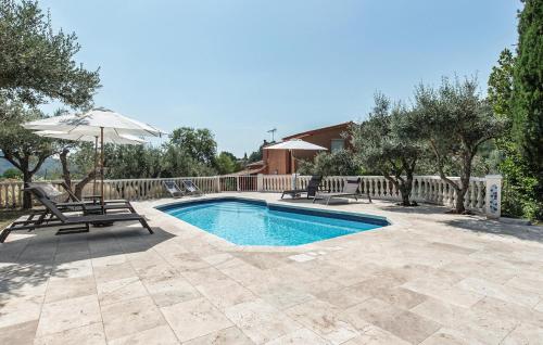 a swimming pool with two chairs and an umbrella at Apartment In Villa With Pool in Callas