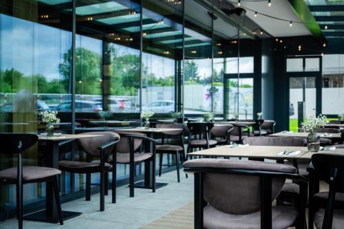 a restaurant with tables and chairs and windows at Wings Plaza in Kraków