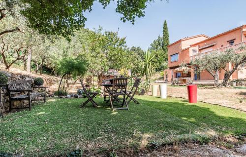 a group of chairs sitting on the grass in a yard at Apartment In Villa With Pool in Callas