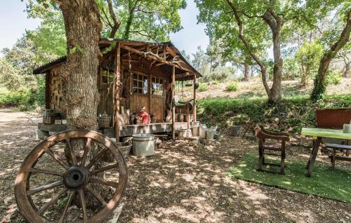 a wooden cabin with a woodenoked wheel next to a tree at Apartment In Villa With Pool in Callas