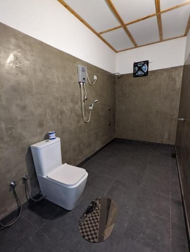 a bathroom with a toilet and a shower at Eco Hotel Black & White - Anuradhapura in Mihintale