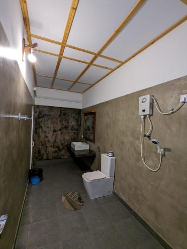 a bathroom with a toilet and a shower at Eco Hotel Black & White - Anuradhapura in Mihintale