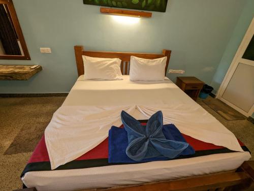 a bedroom with a bed with a bow on it at Eco Hotel Black & White - Anuradhapura in Mihintale