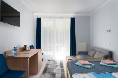 a bedroom with a bed and a desk and a window at Malinka in Rewal