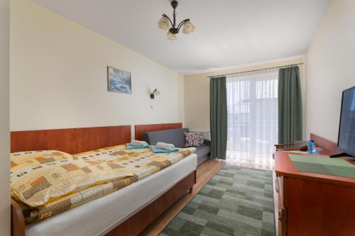 a bedroom with a large bed and a television at Malinka in Rewal