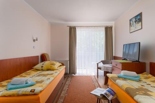 a hotel room with two beds and a television at Malinka in Rewal