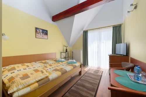 a bedroom with a large bed and a television at Malinka in Rewal