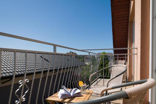 a table and chairs on a balcony with a book at Malinka in Rewal