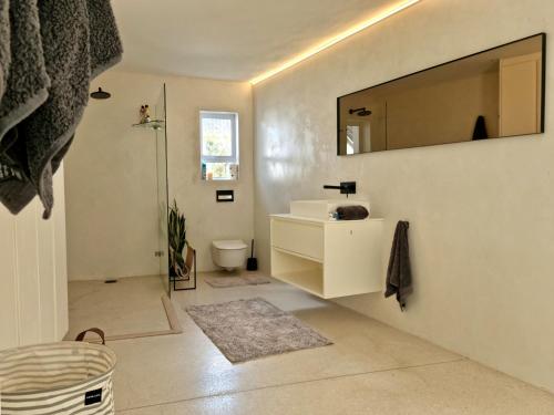 ein Badezimmer mit Waschbecken und Spiegel an der Wand in der Unterkunft 'Kaya Moya' - Luxury Suite for 2 with Ocean Views in Gordonʼs Bay