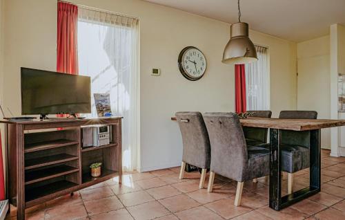 ein Wohnzimmer mit einem Tisch mit Stühlen und einer Uhr in der Unterkunft Westergeest Beneden 2 Slaapk in Uitgeest